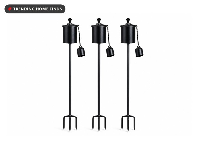 Black metal garden torches with cylinder canisters and ground stakes.