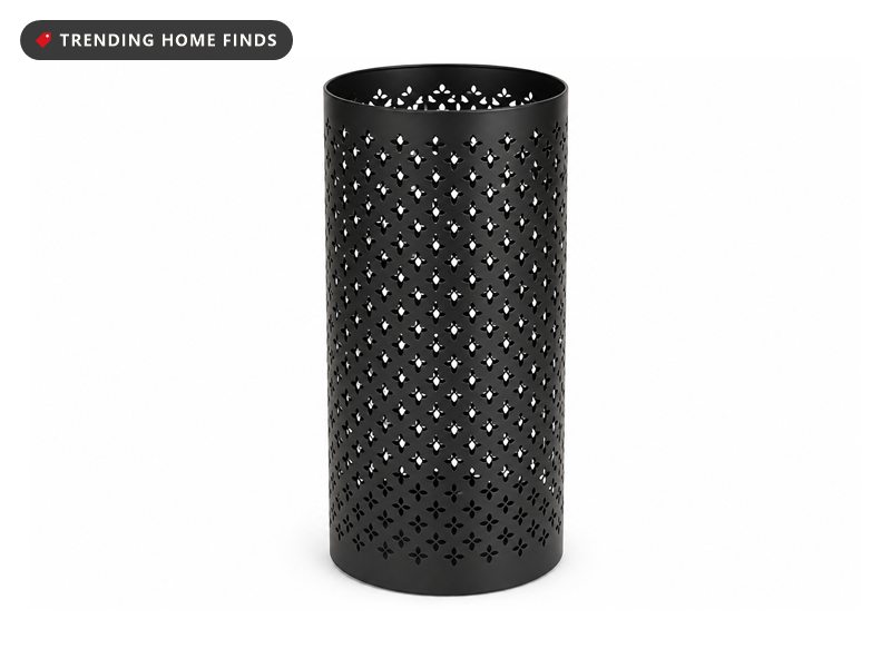 A tall black steel umbrella stand, a straight sided cylinder pierced all over with a small four petal and dot pattern.