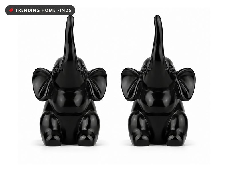 Pair of small black elephant figurines with raised trunks