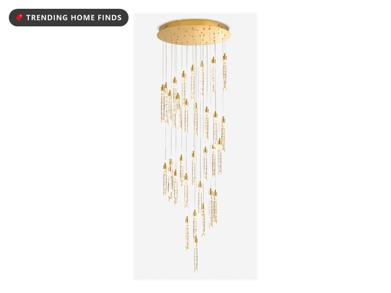 Gold spiral chandelier with thirty hanging tube lights over a staircase