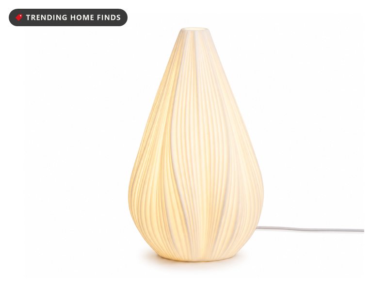 White ribbed ceramic table lamp glowing warm from within