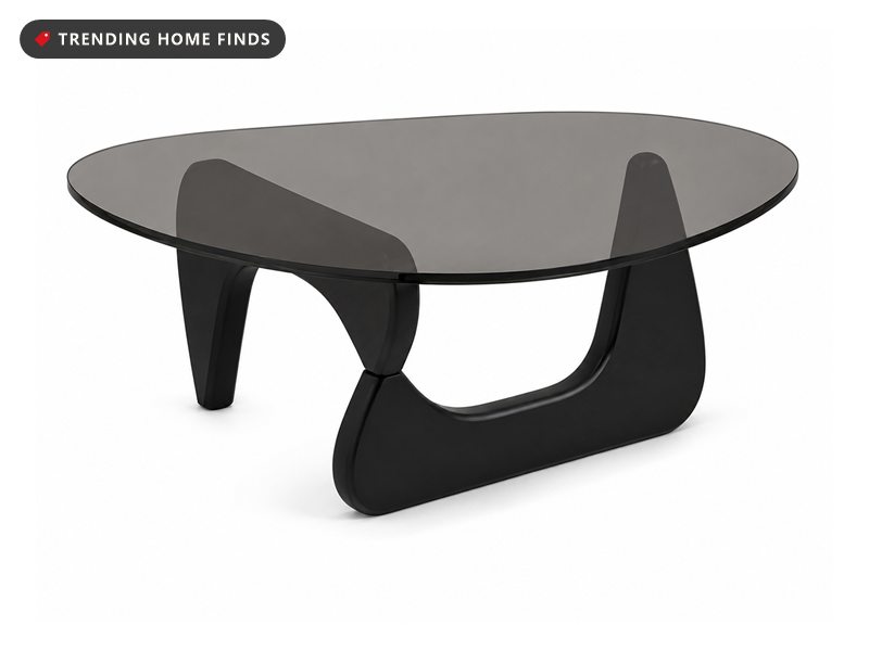 Modern coffee table with a curved smoked glass top on a sculptural black wood base