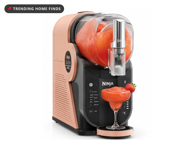 Peach and black Ninja SLUSHi frozen drink maker with a clear hopper of frozen strawberry drink and a dispensing tap