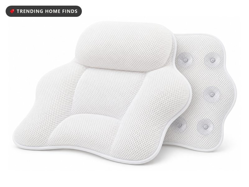 White 4D air mesh bath pillow suctioned inside a white tub filled with bubbles and scattered red petals.