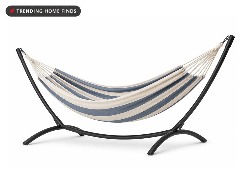 Striped woven cotton double hammock hung on a black steel stand, shown on a white background.
