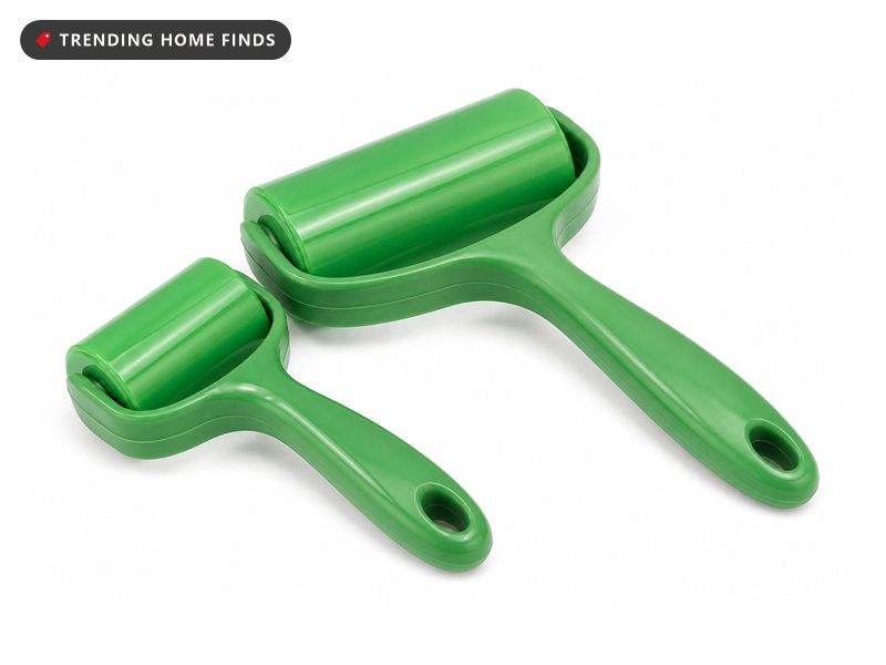 A green gel roller mid-stroke across a charcoal couch cushion in bright midday light, fur lifted onto the roller and the cushion behind left clean.