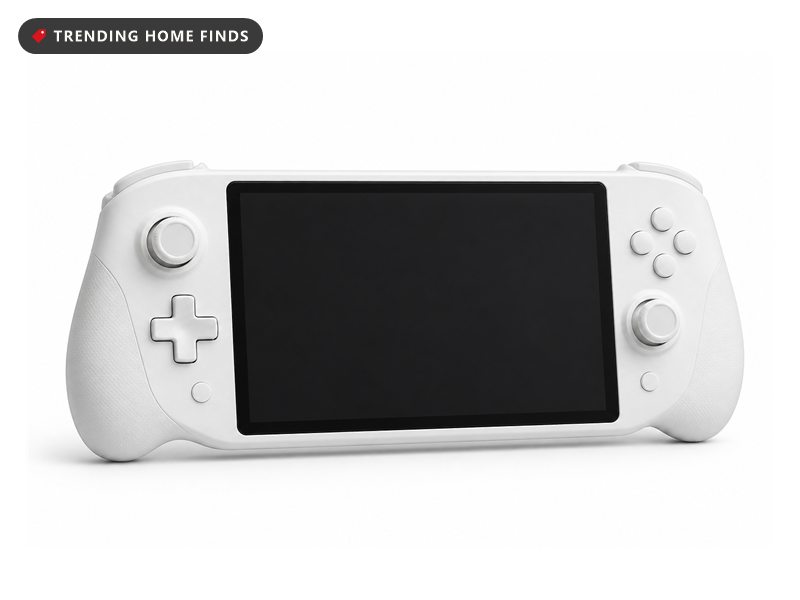 White handheld gaming console docked on a late night desk setup, screen glow spilling over the keyboard, headset resting beside it.