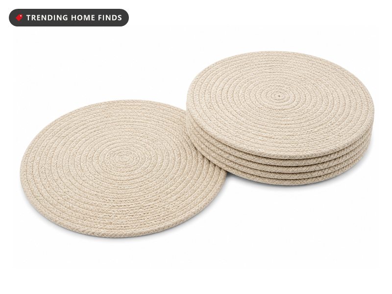 Six round braided cotton rope placemats in natural beige, stacked and fanned.