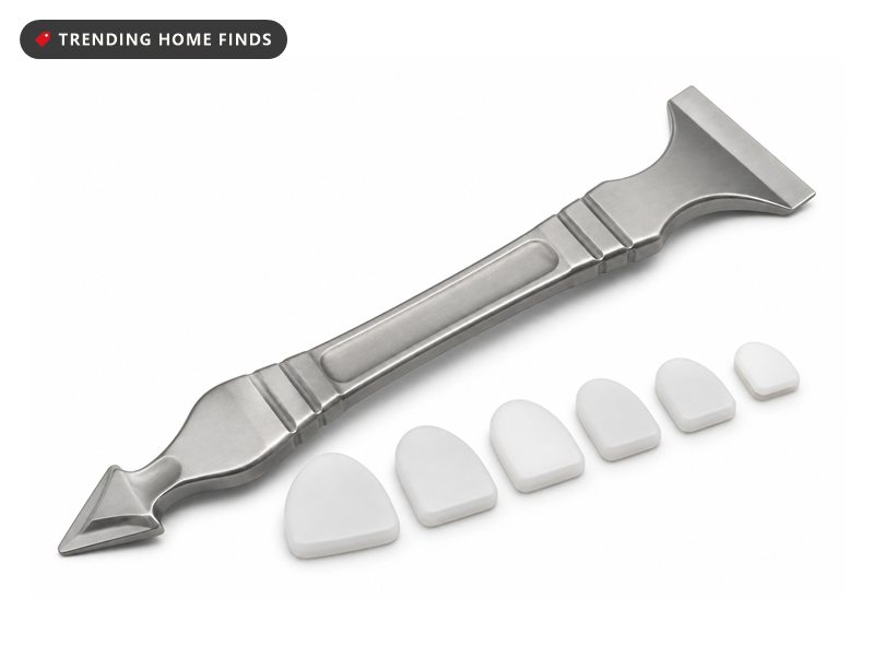 Stainless steel caulking tool with six replaceable silicone pads, applying a fresh white caulk bead along a tub edge