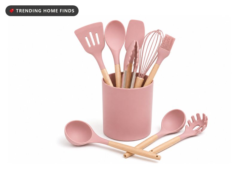 Pink silicone kitchen utensil set with wood handles in a matching crock, on a white background