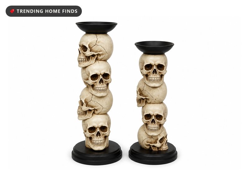 Two candlesticks built from stacked pale skulls on round black bases with wide black candle cups on top.