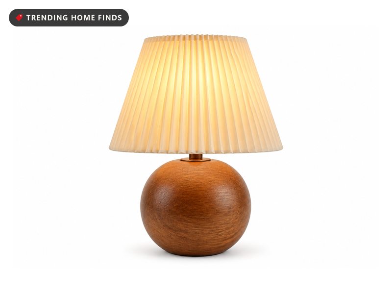 A small table lamp with a pleated cream shade on a round wood grain base.