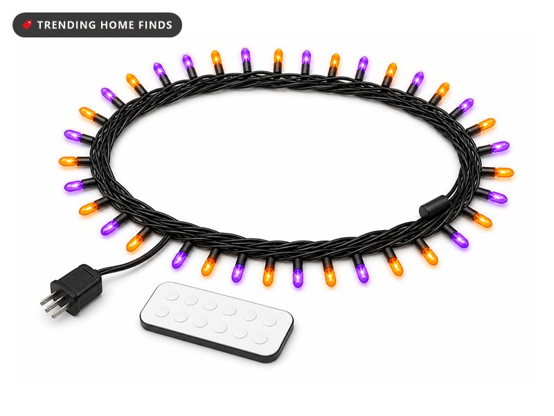 Long string of small orange and purple bulbs on black wire, coiled and lit, with a white remote handset beside it.