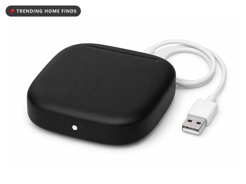 Small matte black rounded square smart remote hub with one white indicator light on the front and a white USB cable coiled beside it.