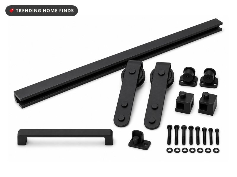 Matte black sliding barn door track laid out with two hanger straps on nylon wheels, door stops, a flat bar handle and a floor guide.