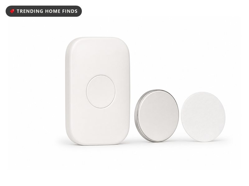 Small white wearable posture sensor with its adhesive pad, on a white background