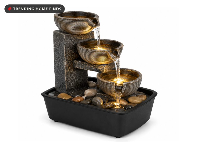 Three-tier stone-look tabletop waterfall fountain with warm LED lighting, water flowing between bowls onto river pebbles