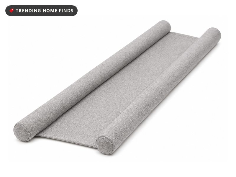 Gray double sided foam draft stopper sliding onto the bottom of a door to seal the gap