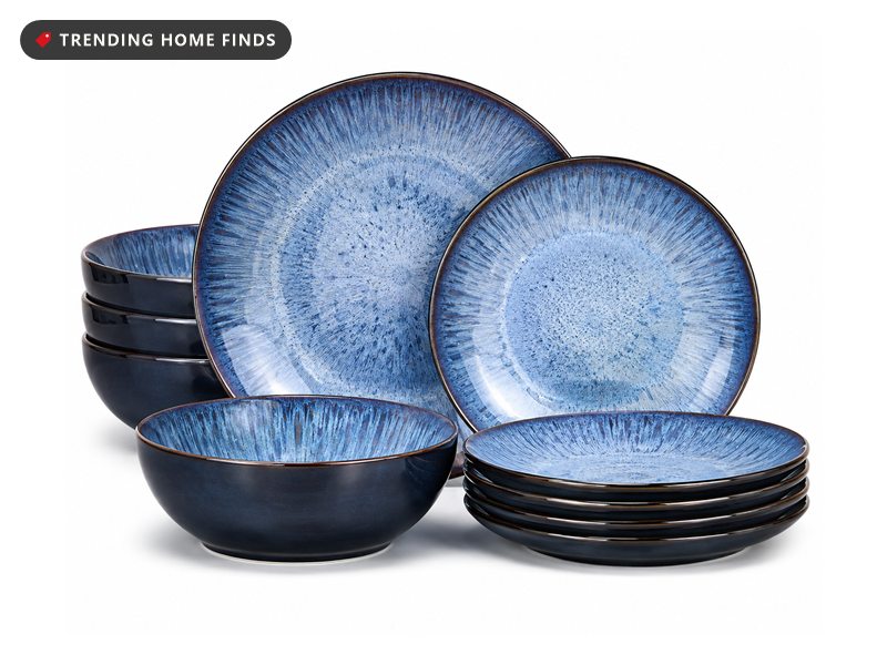 Stacked vancasso ceramic dinnerware in a deep blue reactive glaze, including dinner plates, side plates and bowls with pale speckled centres