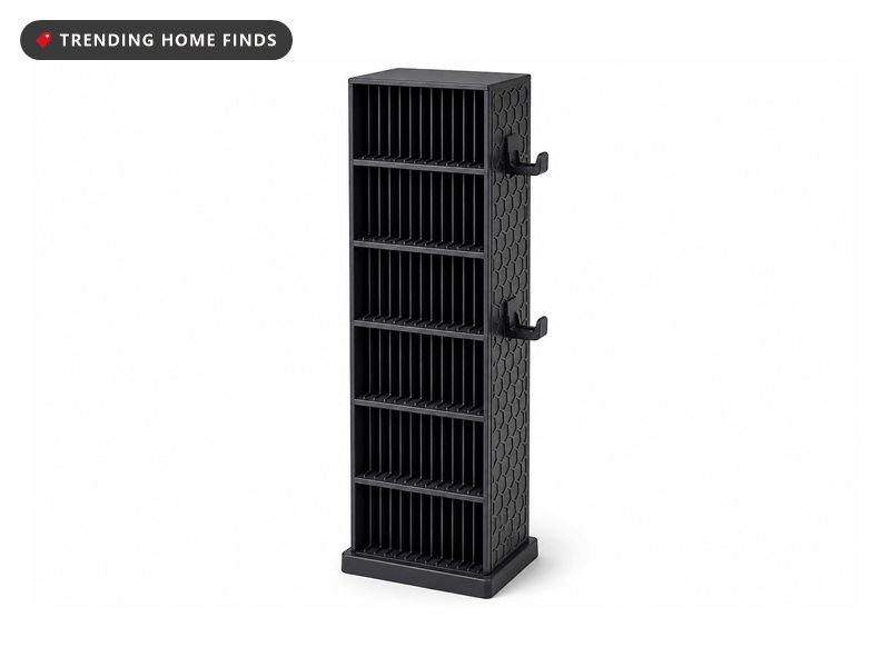 Narrow black storage tower of stacked open shelves divided into fine vertical slots, with two hooks on one side panel.