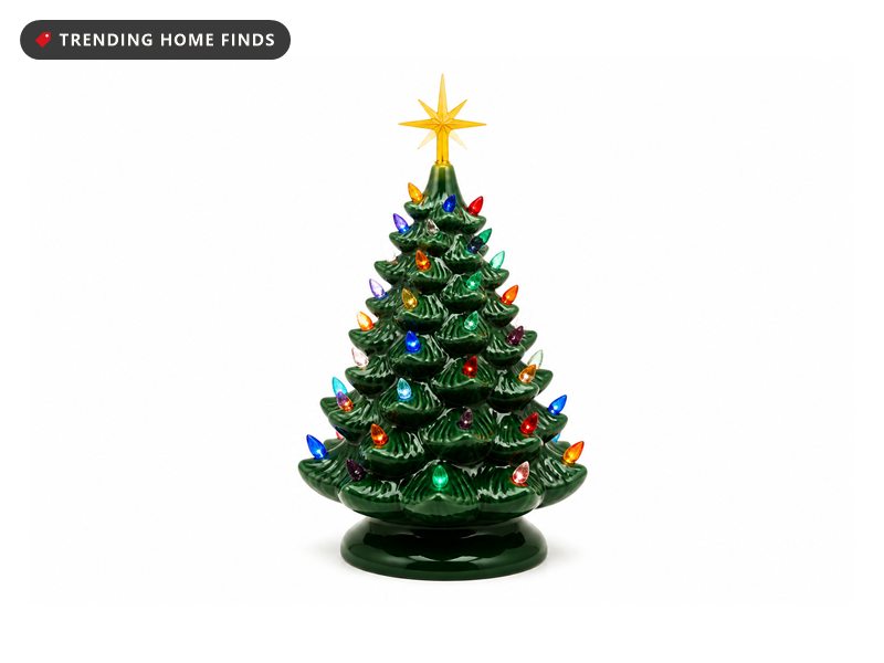 Glossy green ceramic Christmas tree with multicolor bulbs glowing on a tabletop