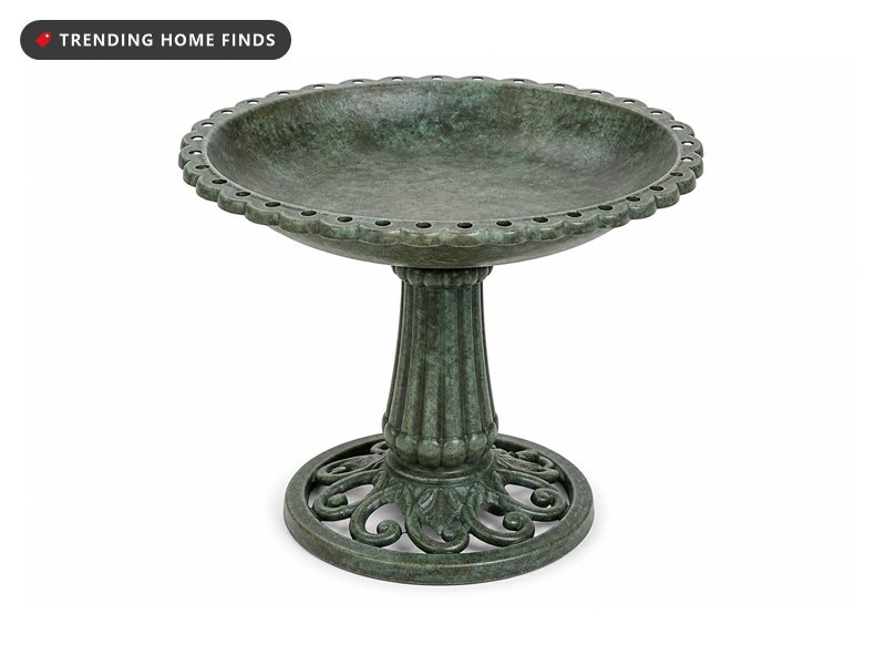 A green antique finish pedestal bird bath with a scalloped rim, fluted column and round openwork base.