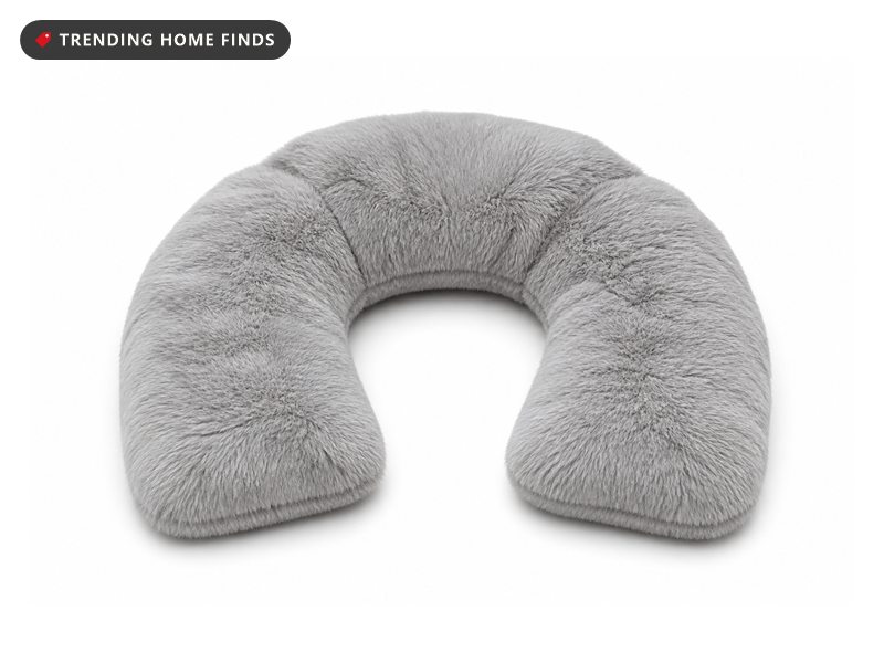 Gray faux fur weighted neck wrap curved into a horseshoe shape with lavender sprigs beside it