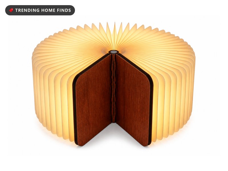 Wooden book lamp shown closed like a hardback and fanned open into a full glowing circle of warm paper pages.
